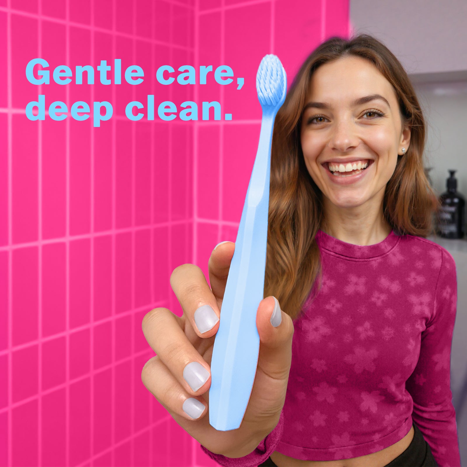 Smiling woman holding a blue Max Toothbrush with extra soft bristles, designed for a gentle clean on sensitive gums.