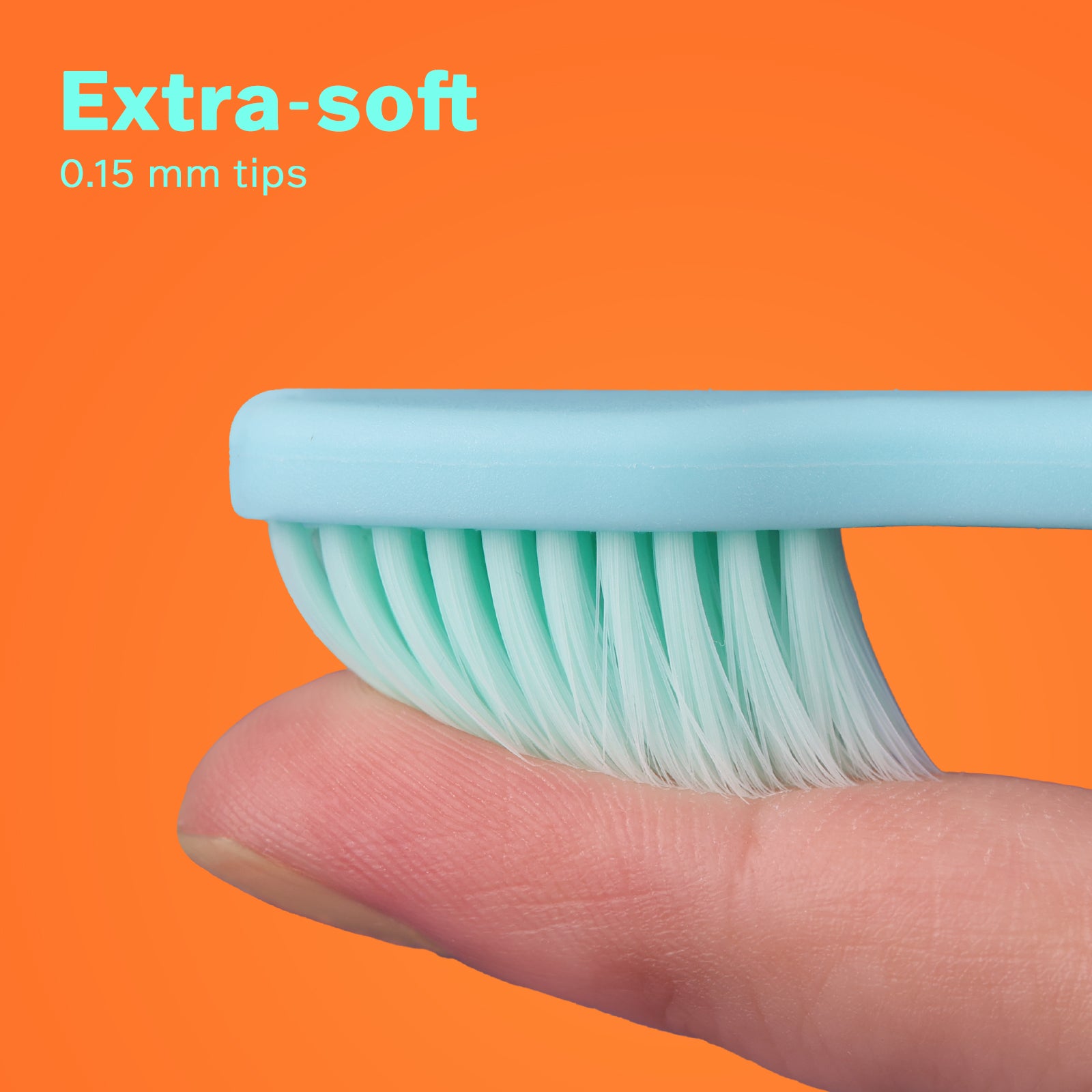 Close-up of extra-soft 0.15 mm green dental brush bristles gently pressed on a finger