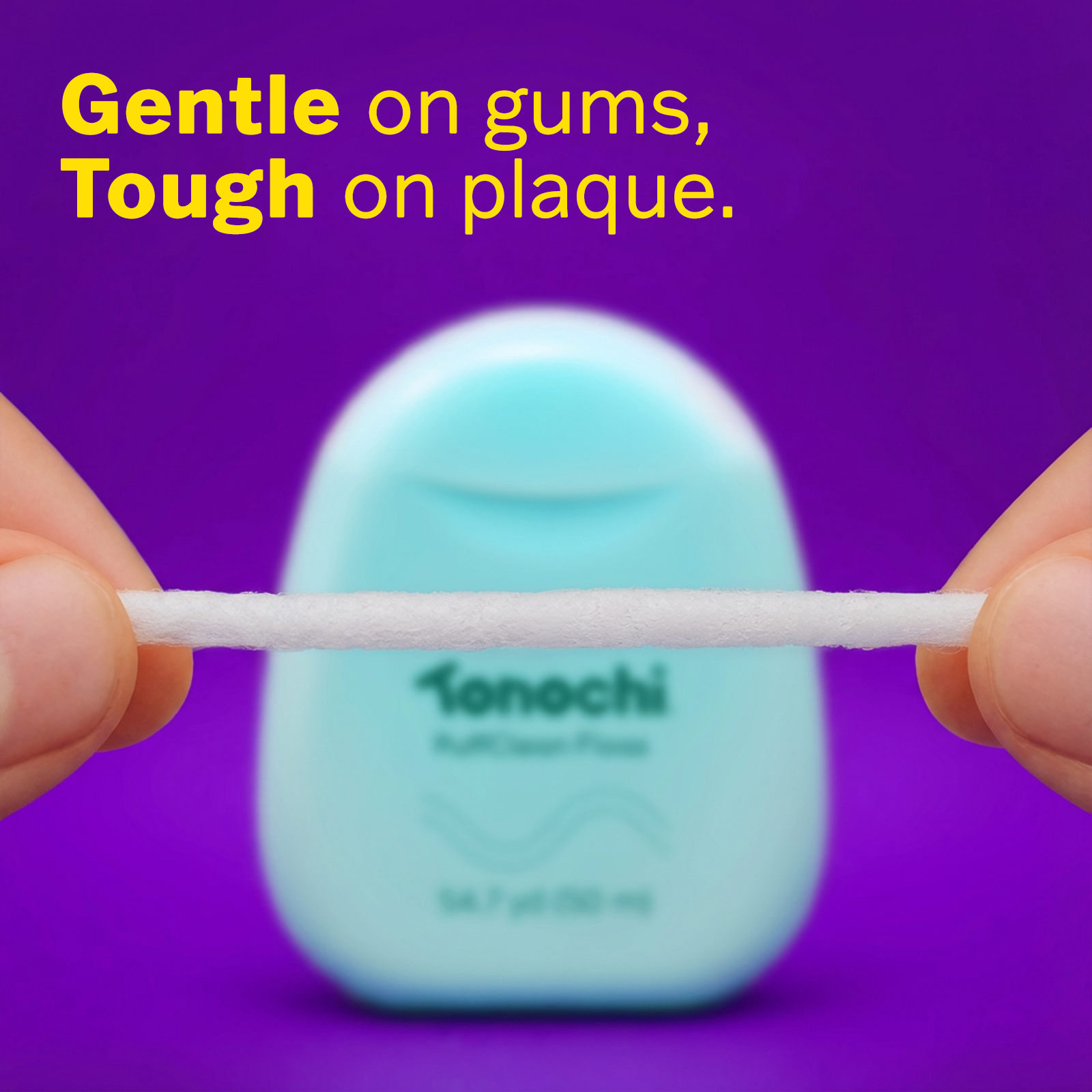 Gentle on gums, Tough on plaque, with a blue dental floss held between two fingers against a purple background.