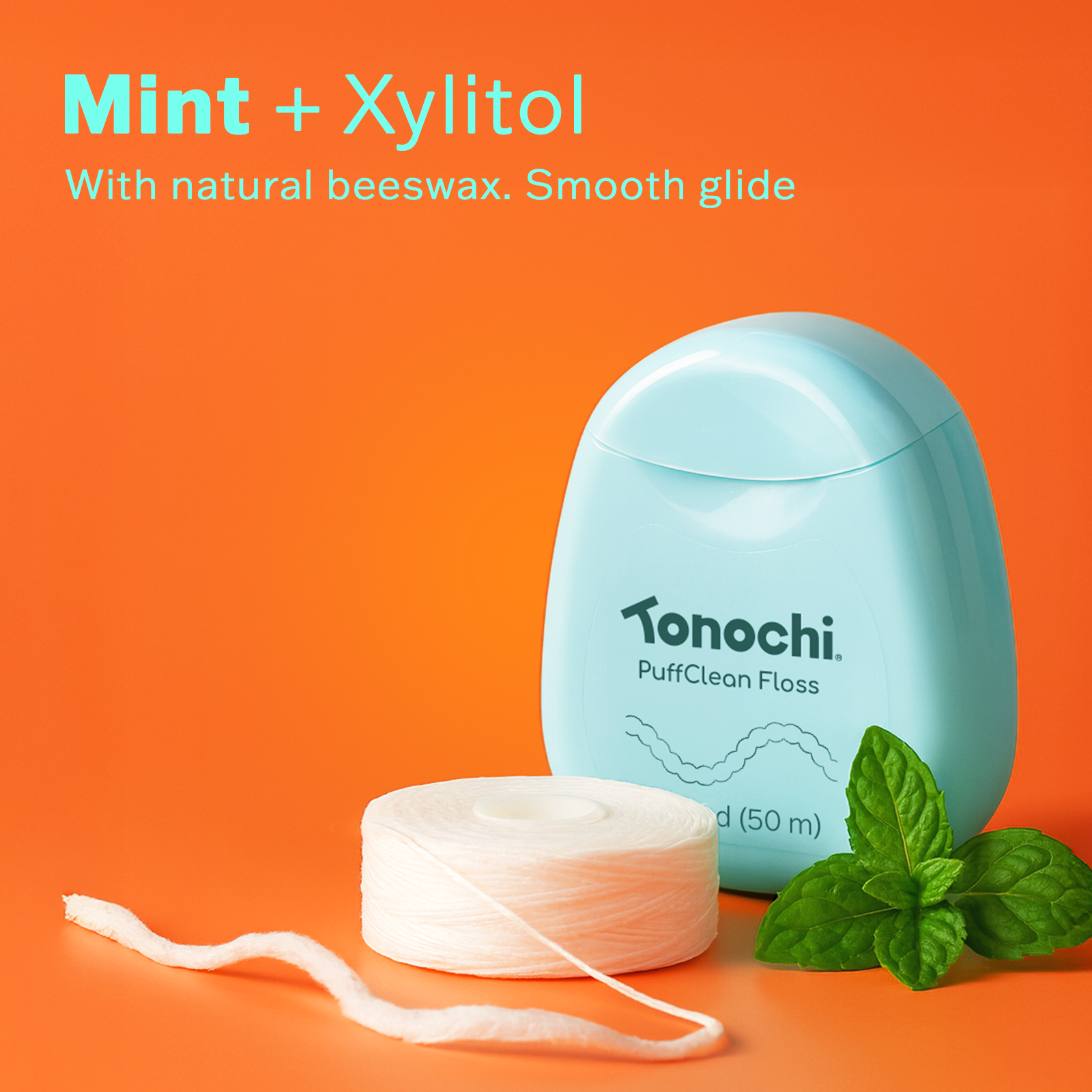 Tonochi PuffClean Floss in mint and xylitol with natural beeswax offers a smooth glide, set against a bright pink background.