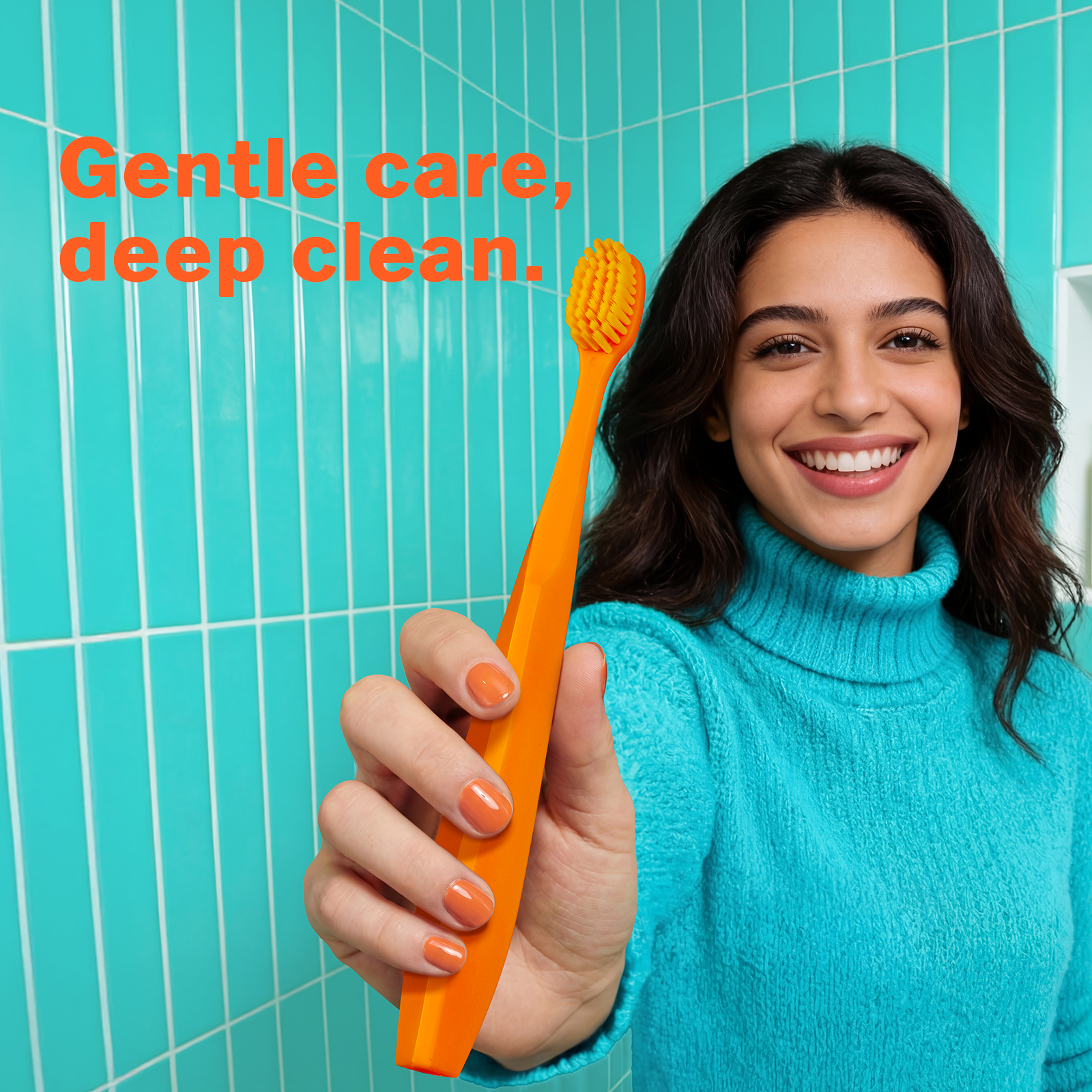 Smiling woman holding a sunset orange Max Toothbrush with extra soft bristles, designed for a gentle clean on sensitive gums.