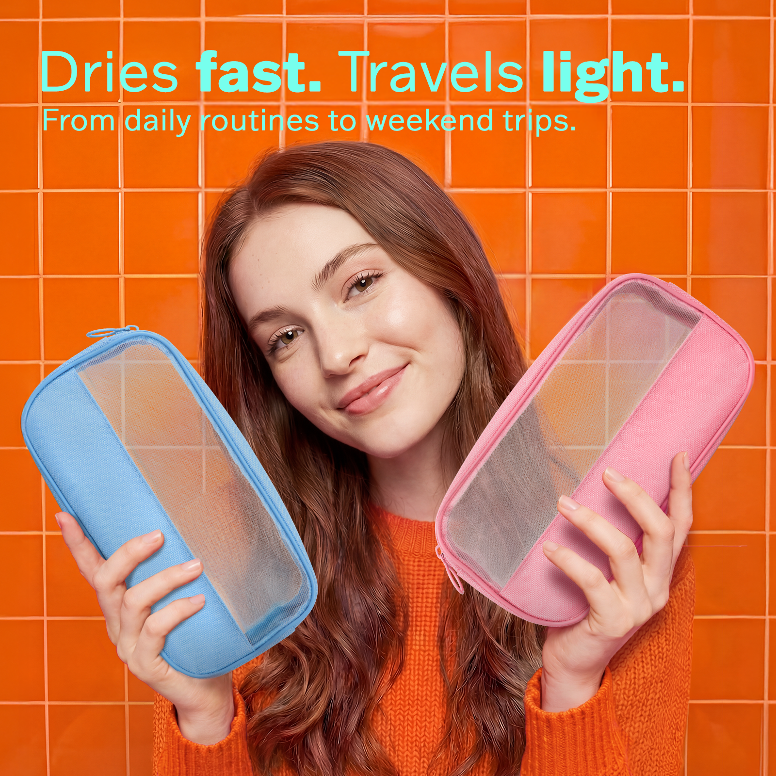 Woman holding a blue and a pink travel case against an orange tiled wall.