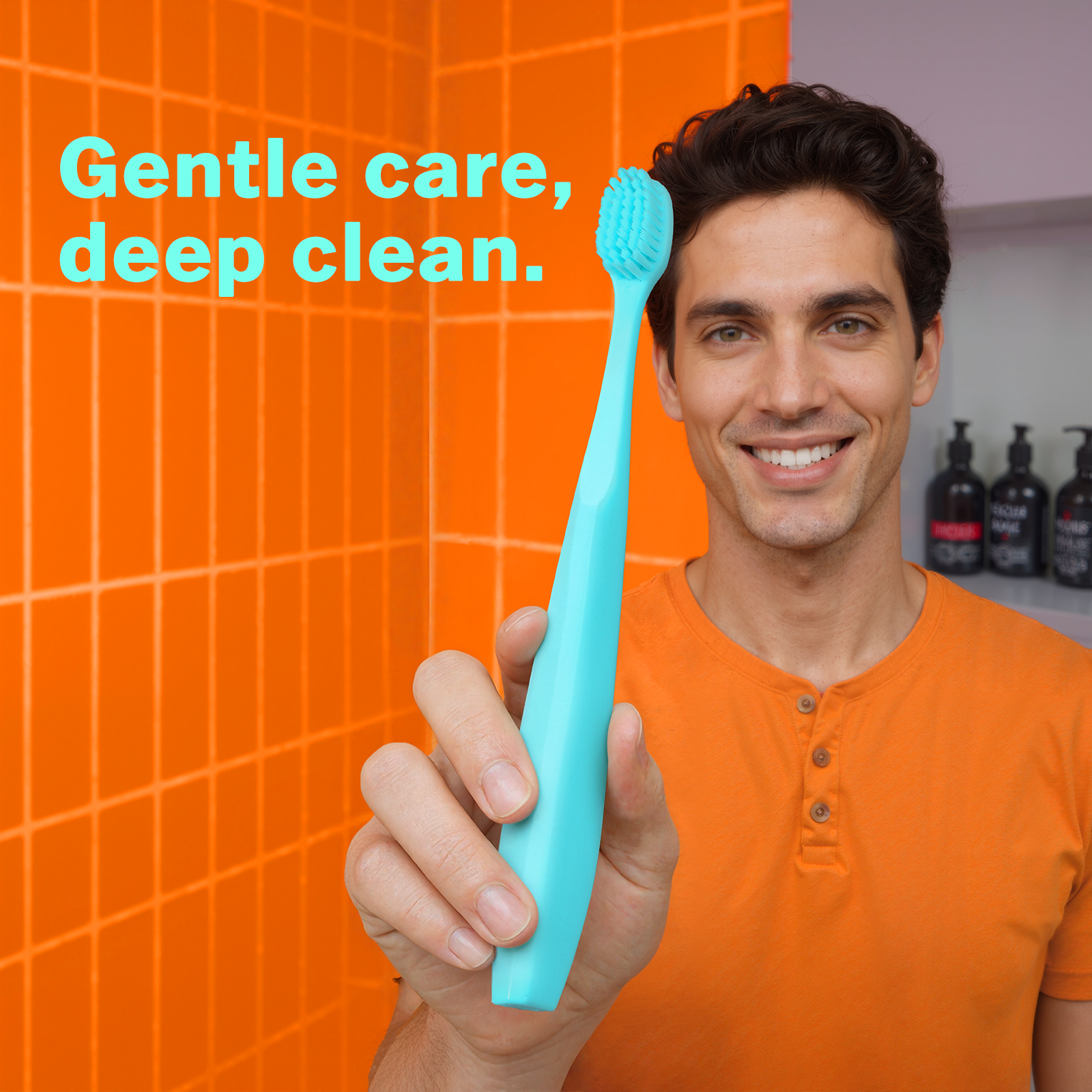 Smiling man holding a mint green Max Toothbrush with extra soft bristles, designed for a gentle clean on sensitive gums.