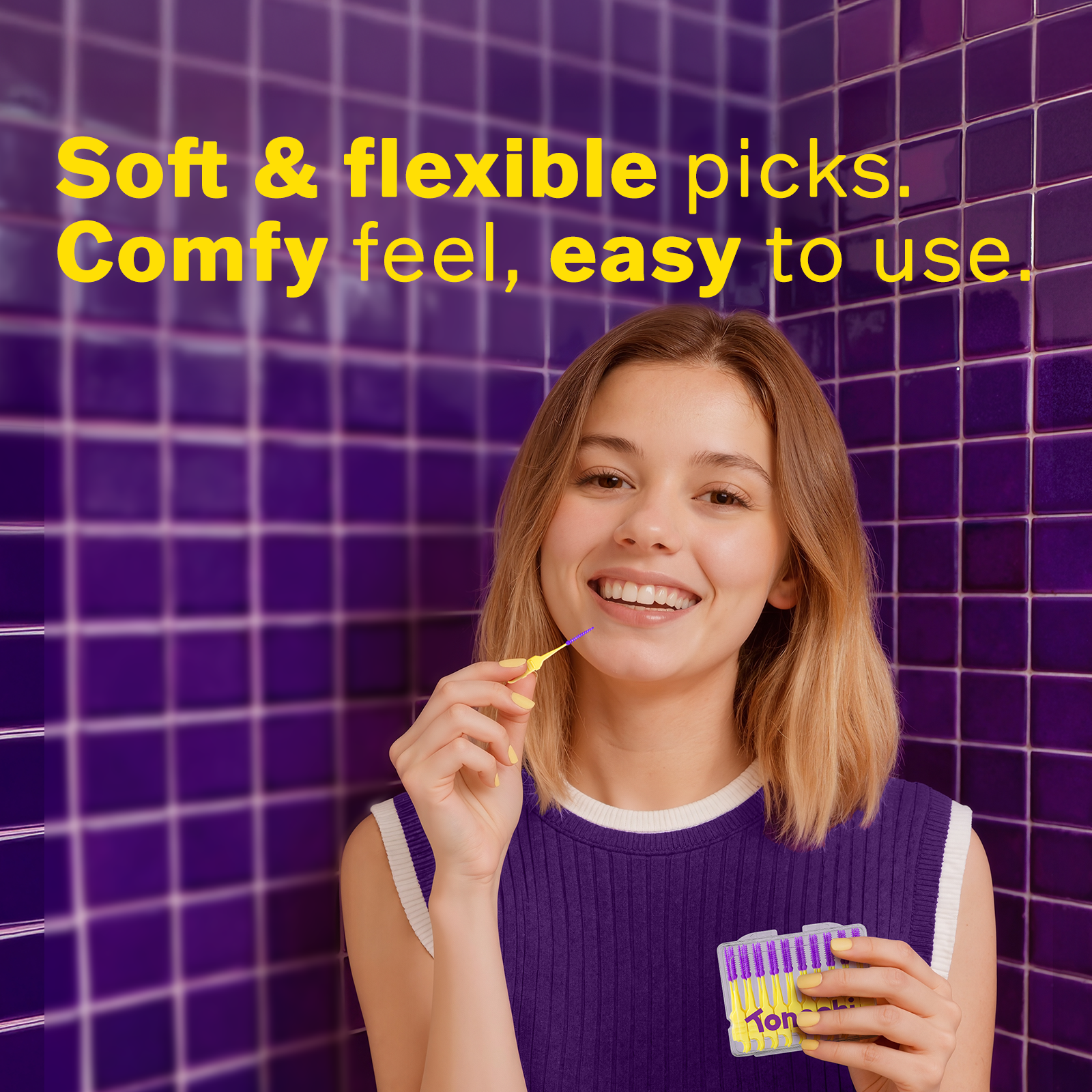 Smiling woman in purple top holding and using soft, flexible Tonochi gum picks in purple tiled background
