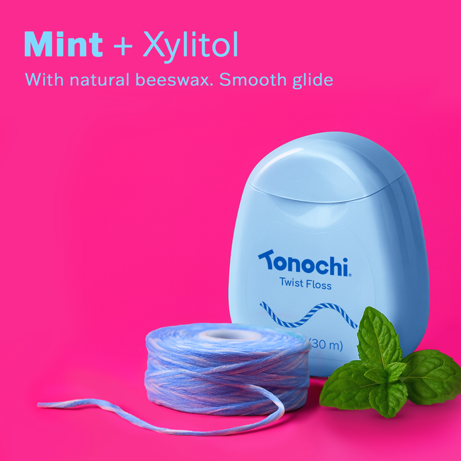 Mint + Xylitol with natural beeswax and smooth glide displayed alongside Tonochi Twist Floss on a vibrant pink background.