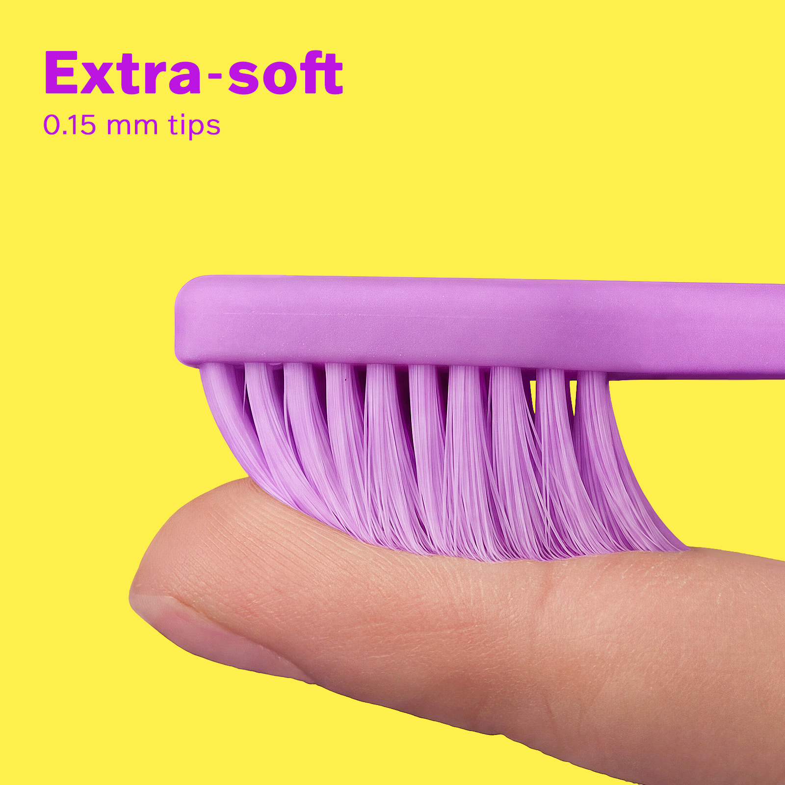 Close-up of extra-soft 0.15 mm lavender dental brush bristles gently pressed on a finger