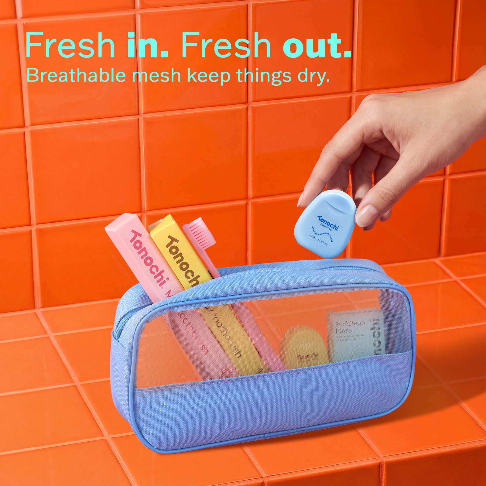Blue toiletry bag with cosmetic items on an orange tiled background